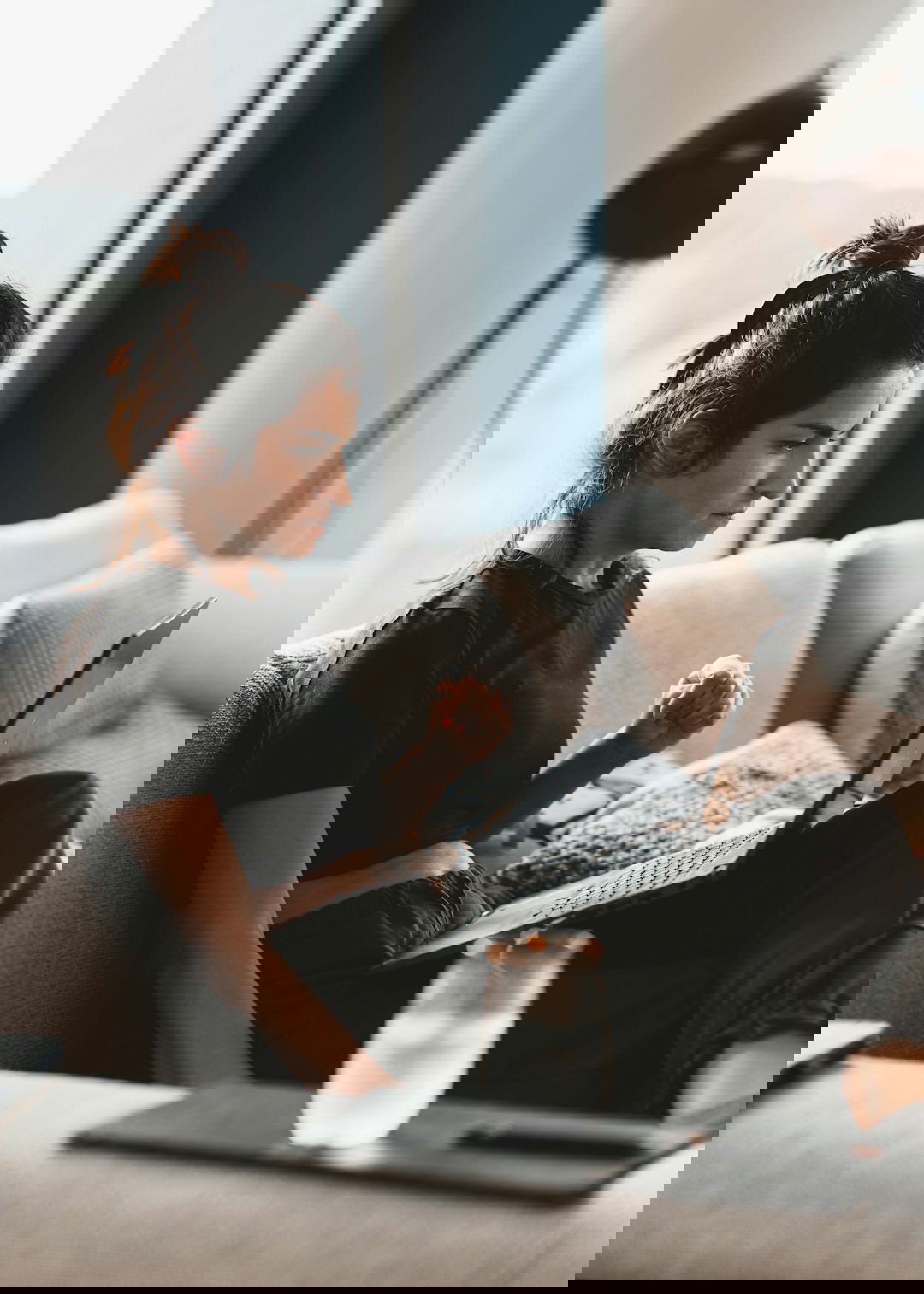 a-woman-sitting-on-a-couch-using-a-laptop-computer.jpg a woman sitting on a couch using a laptop computer